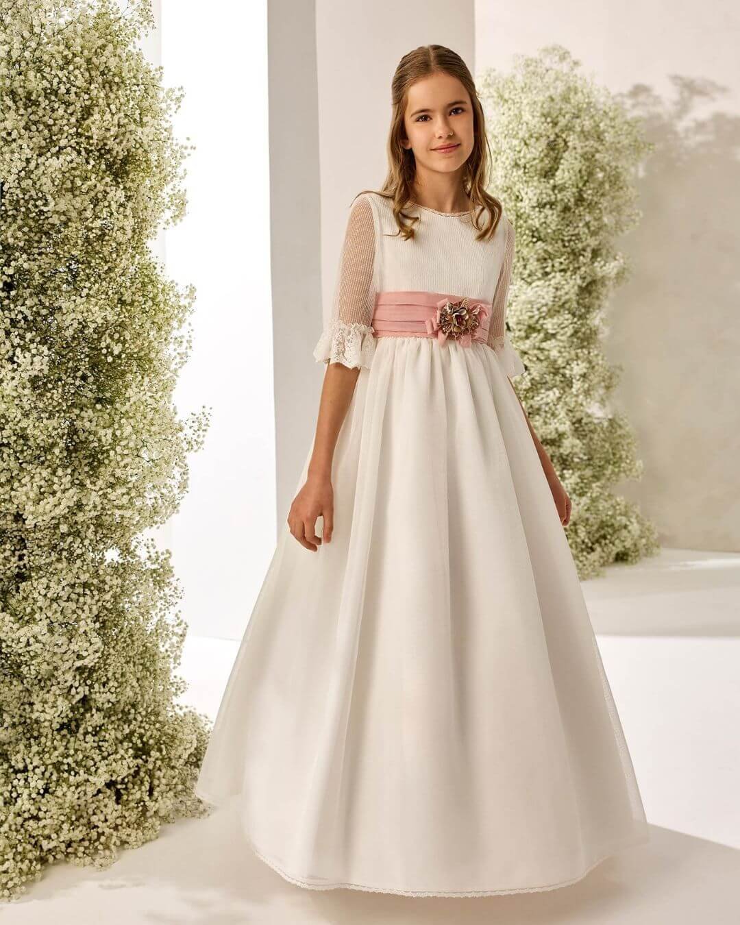 Vestido de Primera Comunión Rosa Clará First en organza con escote barco, manga francesa y fajín rosa - Modas y Confecciones Beatriz